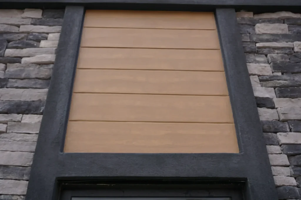 Close-up of horizontal wood grain finish inset panel framed by dark EIFS trim and ledger stone facade surround by Plaster Pro Stucco Contractors serving North Jersey