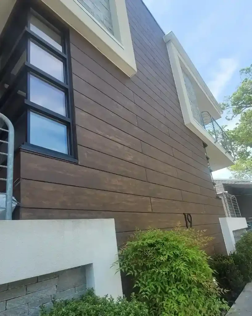 Modern residential home exterior with full horizontal wood grain finish facade panels and white stucco trim by Plaster Pro Stucco Contractors serving North Jersey