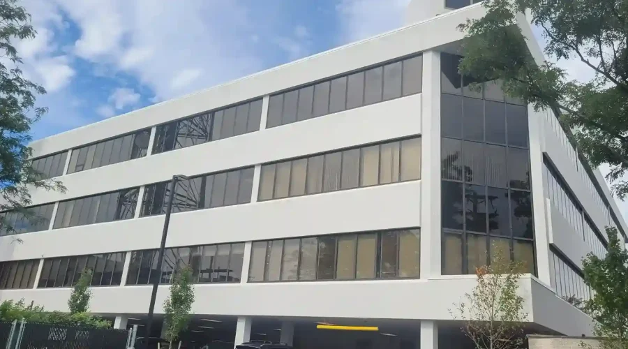 Completed multi-story commercial office building with white EIFS exterior finish and horizontal band detailing by Plaster Pro Stucco Contractors serving North Jersey